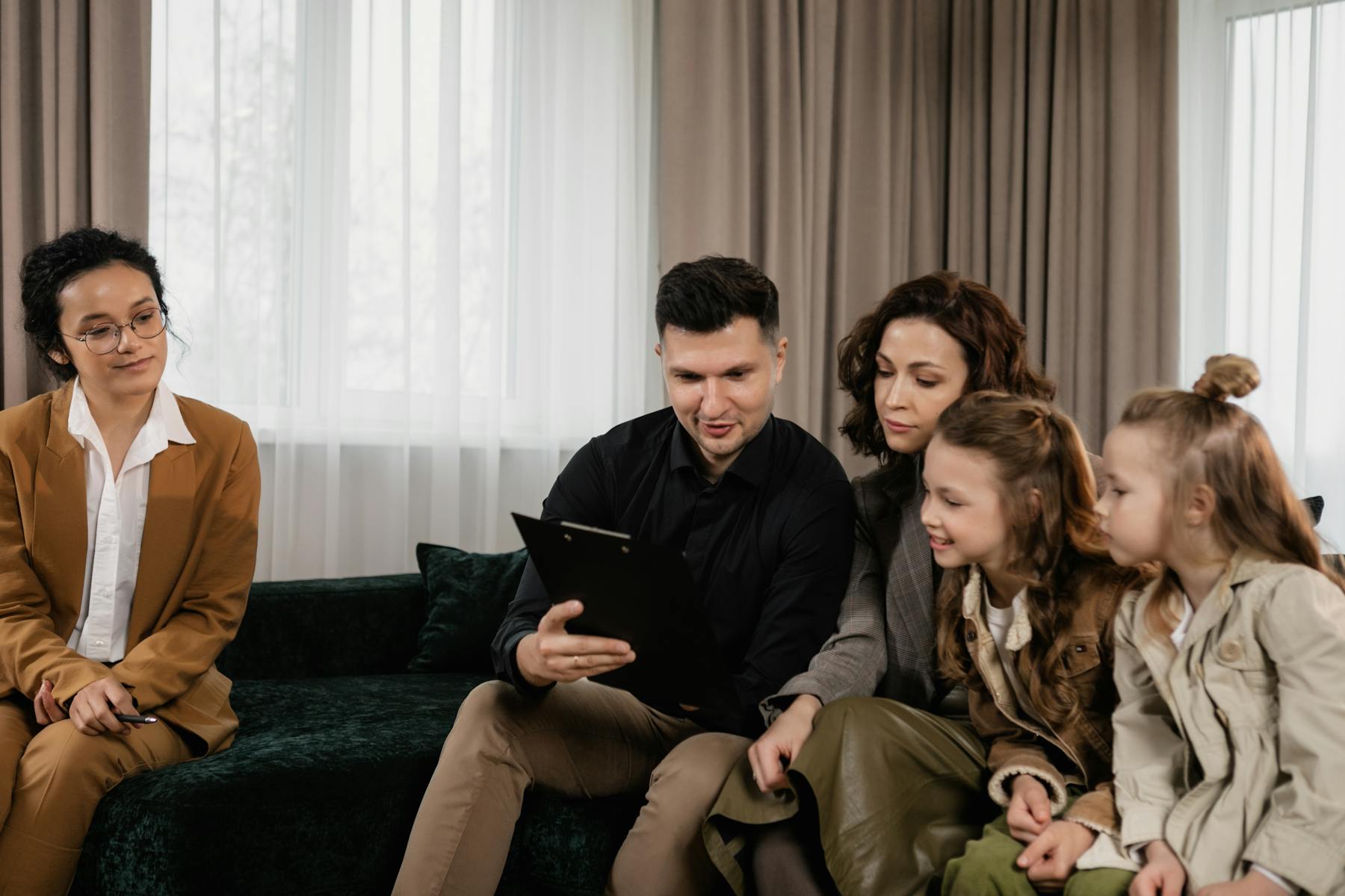Family smiling while reviewing financial documents with an advisor
